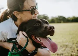 Woman hugging her chocolate lab